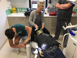 Staff undergoing first aid training in surgery with first aid dummy