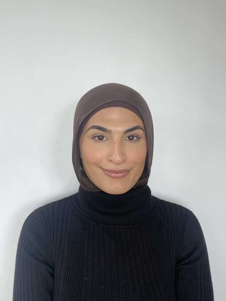 Picture of hygienist Jasmine Donya, smiling while wearing a headscarf